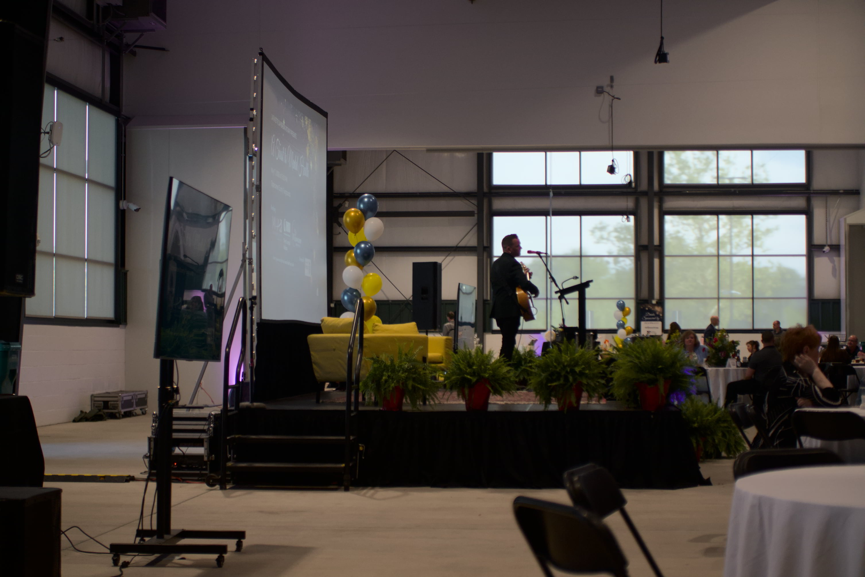 Presenter on stage with projection screen